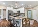 Bright kitchen features granite countertops, stainless steel appliances, island with seating, and pendant lighting at 635 Piping Rock Pt, Lawrenceville, GA 30043