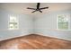 Bright bedroom featuring hardwood floors, neutral walls with clean, white trim, and great natural lighting from the windows at 1106 Oak Sw Rd, Lilburn, GA 30047