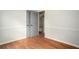 A spacious bedroom with hardwood floors and neutral walls, featuring multiple doorways leading to other rooms in the house at 1106 Oak Sw Rd, Lilburn, GA 30047
