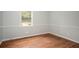 Well-lit bedroom featuring hardwood floors, neutral walls with clean, white trim, and great natural lighting from the window at 1106 Oak Sw Rd, Lilburn, GA 30047
