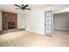 Living room showing wood-look flooring, a rustic brick fireplace, and a doorway to another room at 1106 Oak Sw Rd, Lilburn, GA 30047