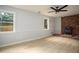 Living room boasts wood-look flooring, two windows, and a rustic brick fireplace with black accent stove at 1106 Oak Sw Rd, Lilburn, GA 30047