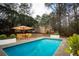Inviting backyard with a refreshing pool and an umbrella covered dining set at 1106 Oak Sw Rd, Lilburn, GA 30047