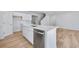 Bright kitchen island featuring stainless steel dishwasher, white cabinets and quartz countertops at 517 Elkwood Ln, Mcdonough, GA 30253