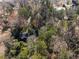 Aerial view of a treed property with a peek of the house and outbuildings at 3200 Wood Valley Nw Rd, Atlanta, GA 30327