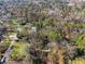 Aerial view of wooded lot, other large properties, and city skyline in background at 3200 Wood Valley Nw Rd, Atlanta, GA 30327
