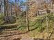 A view of the backyard, with a partial stone wall, mature trees and greenery at 3200 Wood Valley Nw Rd, Atlanta, GA 30327