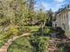 Secluded backyard featuring lush landscaping, mature trees, and a charming brick patio, perfect for outdoor living at 3200 Wood Valley Nw Rd, Atlanta, GA 30327