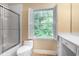 Bathroom featuring shower, toilet, vanity, and bright window at 3200 Wood Valley Nw Rd, Atlanta, GA 30327