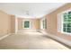 Spacious bedroom featuring neutral carpet, three windows offering natural light, and ceiling fan at 3200 Wood Valley Nw Rd, Atlanta, GA 30327