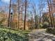 Long paved driveway leading to a residence, lined with lush ground cover and mature trees at 3200 Wood Valley Nw Rd, Atlanta, GA 30327