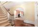 Inviting entryway featuring a carpeted staircase, hardwood floors, and arched doorways leading to a living room at 3200 Wood Valley Nw Rd, Atlanta, GA 30327