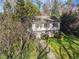 Attractive two-story home featuring a stone foundation, lush landscaping, and a classic architectural style surrounded by mature trees at 3200 Wood Valley Nw Rd, Atlanta, GA 30327