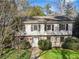 Charming two-story home featuring a stone facade, lush landscaping, and a welcoming entrance amidst mature trees at 3200 Wood Valley Nw Rd, Atlanta, GA 30327