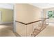 Bright upstairs hallway featuring staircase, neutral carpeting, and a large window with scenic outdoor views at 3200 Wood Valley Nw Rd, Atlanta, GA 30327