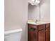 Cozy bathroom with cherry cabinets and a neutral countertop, along with a simple white toilet at 1315 Thunder Gulch Pass, Suwanee, GA 30024