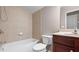 Full bathroom featuring a tiled tub, vanity with dark cabinets, and a modern toilet at 1315 Thunder Gulch Pass, Suwanee, GA 30024