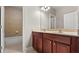 Bathroom featuring a double vanity with dark wood cabinets and tiled tub at 1315 Thunder Gulch Pass, Suwanee, GA 30024