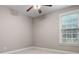 Bedroom features neutral paint, a ceiling fan, and a window with natural light at 1315 Thunder Gulch Pass, Suwanee, GA 30024