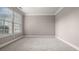 Bedroom featuring gray walls, white trim, and a large window with blinds at 1315 Thunder Gulch Pass, Suwanee, GA 30024