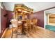 Custom bar in basement featuring bar seating, hardwood floors, and a built-in refrigerator at 1574 Stepstone Way, Lawrenceville, GA 30043
