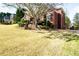 Exterior angle view of a red brick home with lush green lawn and tasteful landscaping in a suburban neighborhood at 1574 Stepstone Way, Lawrenceville, GA 30043