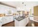 Modern kitchen with white cabinets, stainless steel appliances, kitchen island, and hardwood floors at 1574 Stepstone Way, Lawrenceville, GA 30043