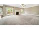 Large carpeted living room with sliding glass doors, fireplace, and ceiling fan at 1574 Stepstone Way, Lawrenceville, GA 30043