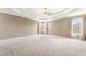 Spacious main bedroom featuring tray ceiling, plush carpet and large windows providing ample natural light at 1574 Stepstone Way, Lawrenceville, GA 30043