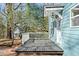 Rear porch with gray floorboards, white railings, light blue siding, and black outdoor light fixture at 227 Sydney Se St, Atlanta, GA 30312