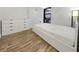 Bedroom featuring white interior, modern dresser, wood floors, and large window at 620 Peachtree Ne St # 503, Atlanta, GA 30308