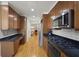 Sleek kitchen with stainless steel appliances, dark countertops, wood cabinets, and hardwood flooring at 1735 Peachtree Ne St # 227, Atlanta, GA 30309