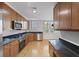 Well-lit kitchen with stainless steel appliances, wooden cabinets, and dark granite countertops at 1735 Peachtree Ne St # 227, Atlanta, GA 30309