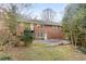 View of a brick home exterior with a concrete patio surrounded by trees at 2330 Bonnybrook Way, East Point, GA 30344