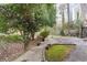 A backyard with concrete areas and shrubbery, with a home visible in the distance at 2330 Bonnybrook Way, East Point, GA 30344