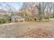 A wide shot of a one-story brick home featuring a large front yard with mature trees at 2330 Bonnybrook Way, East Point, GA 30344