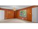 Cozy living room with wood paneling, a classic light fixture, and natural light from a window at 2330 Bonnybrook Way, East Point, GA 30344