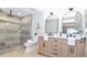 Elegant bathroom featuring a double vanity, large mirrors, and a luxurious walk-in shower with marble-style tile at 642 Austin Se Dr, Smyrna, GA 30082