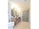 Well-lit bathroom with a double vanity, arched mirrors, and a view of the tile flooring at 642 Austin Se Dr, Smyrna, GA 30082