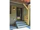 Inviting entryway with steps up to a brick house showcasing a custom wood railing at 642 Austin Se Dr, Smyrna, GA 30082