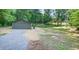 View of backyard shed with gravel driveway and grassy surrounding area at 642 Austin Se Dr, Smyrna, GA 30082