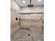 Close-up of the marble-style tiled shower with a rainfall shower head and a pebble-style shower floor at 642 Austin Se Dr, Smyrna, GA 30082