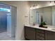 Modern bathroom featuring double sinks with a large framed mirror, a glass door shower, and neutral color palette at 325 Sassafras W Way, Holly Springs, GA 30115