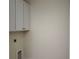 Functional laundry room with upper cabinets and space for washer and dryer, offering convenience at 325 Sassafras W Way, Holly Springs, GA 30115