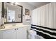 Clean bathroom featuring a shower with a black and white striped curtain and a vanity with a large mirror at 586 Devon Brooke Dr, Woodstock, GA 30188