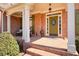 Charming brick porch featuring rocking chairs and a welcoming olive front door at 586 Devon Brooke Dr, Woodstock, GA 30188