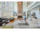 Comfortable living room featuring a stone fireplace, built-in shelving, and large windows offering plenty of light at 586 Devon Brooke Dr, Woodstock, GA 30188