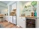 Elegant wet bar with white cabinetry, stainless steel appliances, and stylish glass shelving at 586 Devon Brooke Dr, Woodstock, GA 30188