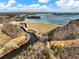 Scenic aerial view of a dam and lake surrounded by dense trees and rolling hills at 6734 Pass Road, Buford, GA 30518