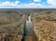 Breathtaking aerial shot showcasing a winding river cutting through lush, forested terrain at 6734 Pass Road, Buford, GA 30518